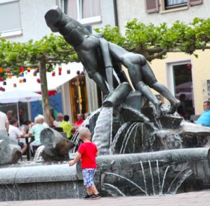 Brunnen auf dem Rathausplatz mit spielendem Kind